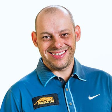 A man in a blue shirt smiling for a picture