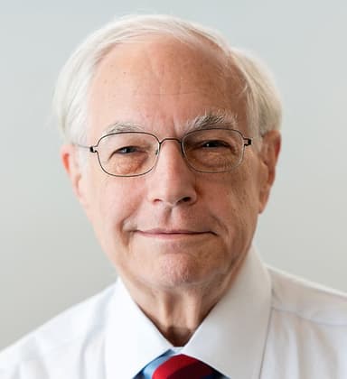 An older man wearing glasses and a tie