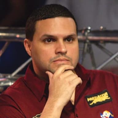 A man in a red shirt with his hand on his chin