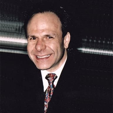 A man in a suit and tie smiling at the camera