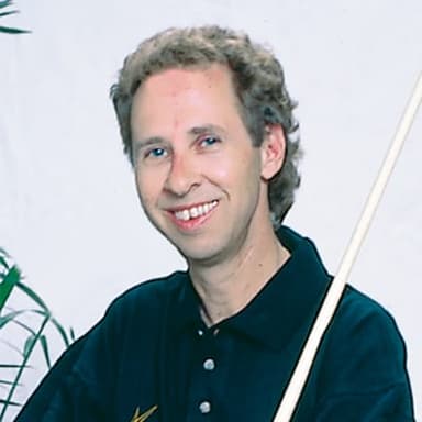 A man is holding a baseball bat and smiling