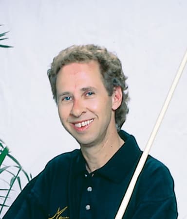 A man is holding a baseball bat and smiling