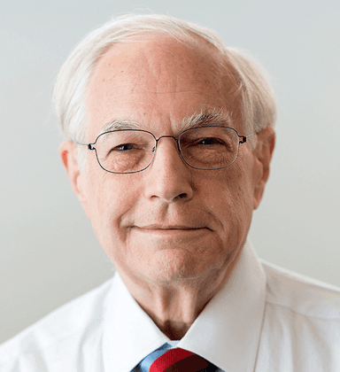 An older man wearing glasses and a tie