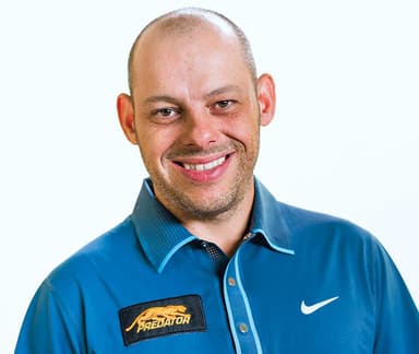 A man in a blue shirt smiling for a picture
