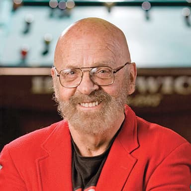 A man with a beard and glasses is smiling